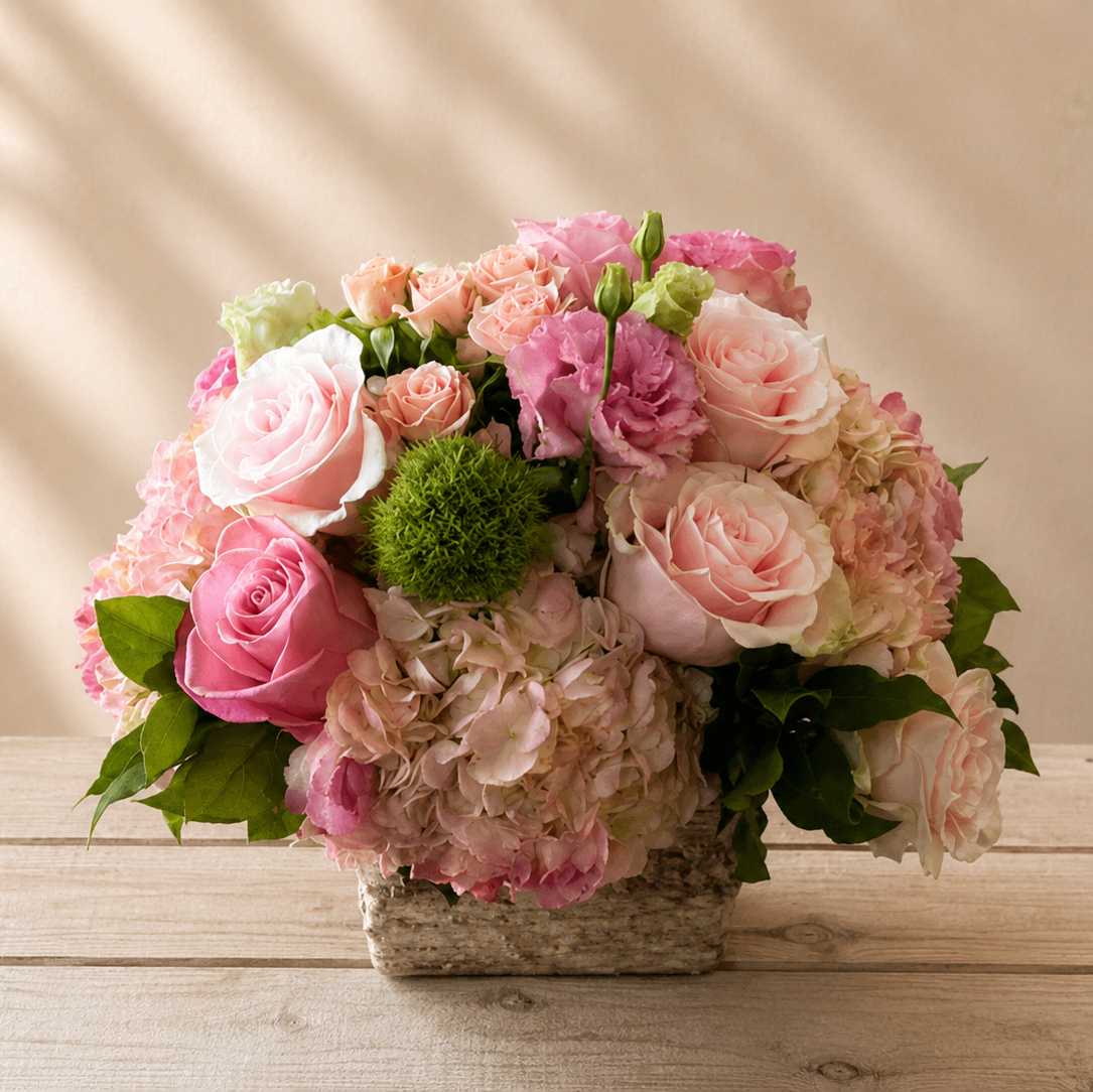 Bouquet of pink and white flowers on a wooden surface with a beige background